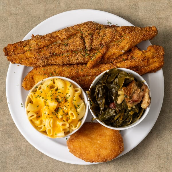 IDA MAE’S soul-food platter with fried fish, mac and cheese, collard greens, and a fried patty.